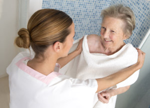 caregiver assisting old woman to take a bath